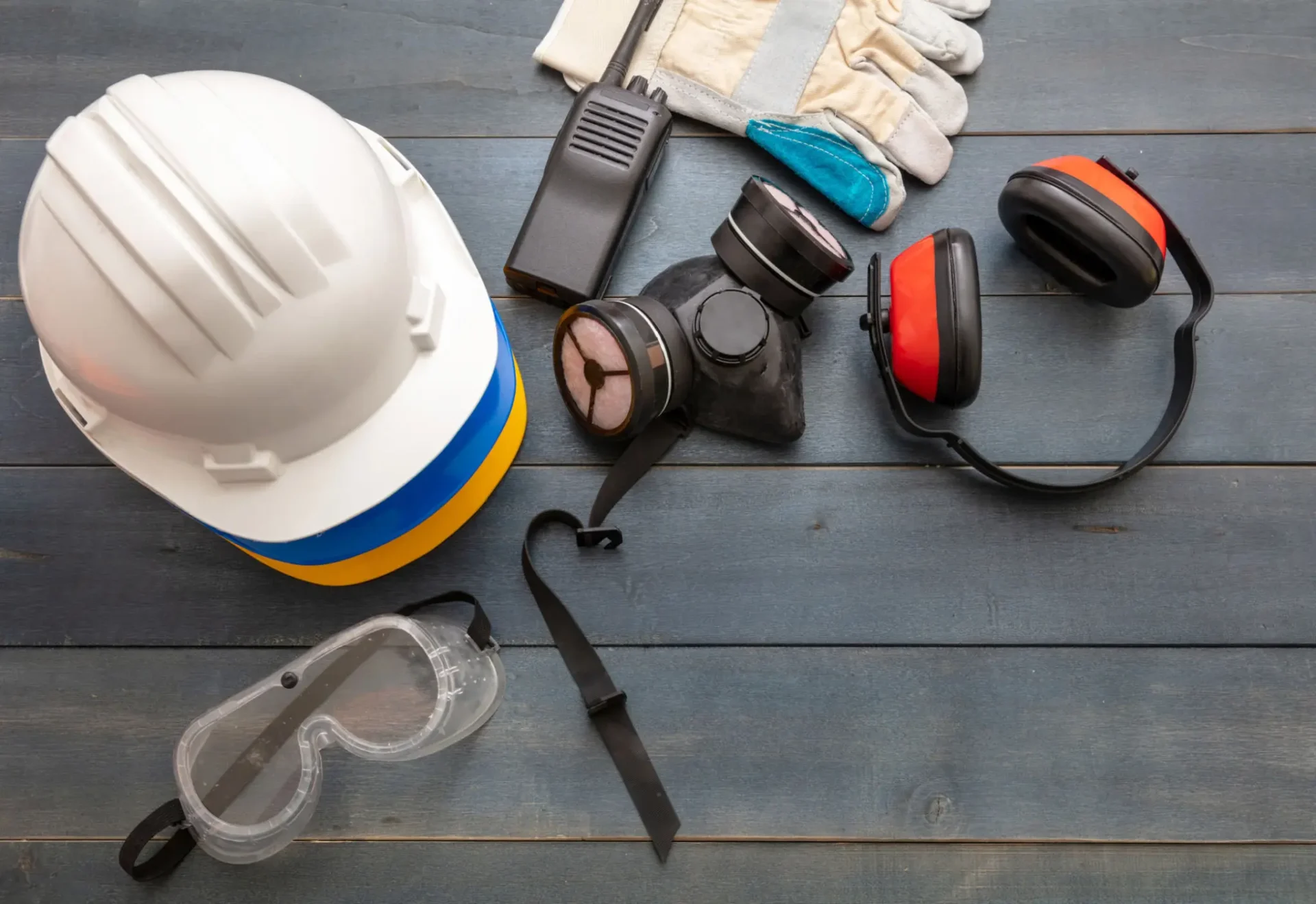 Essential safety gear for industrial work including helmet, mask, gloves, and goggles.